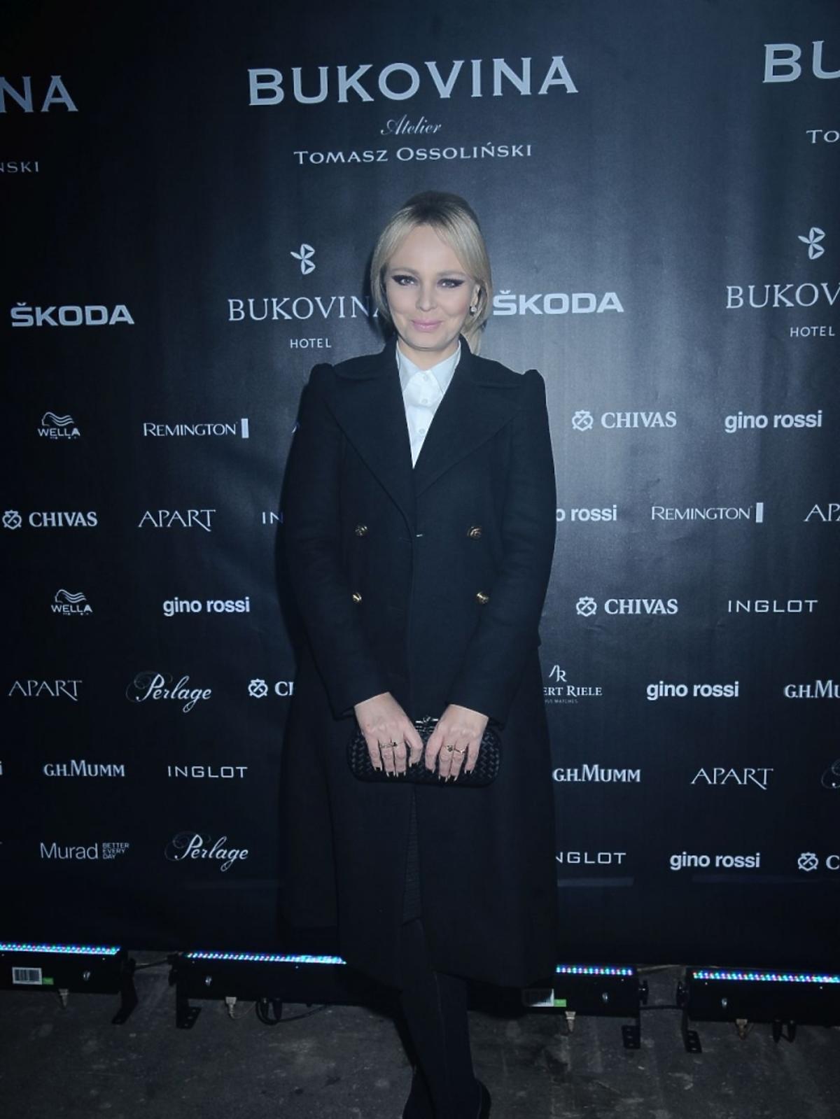 Agnieszka Jastrzębska w czarnym płaszczu i białej koszuli na pokazie Tomasza Ossolińskiego
