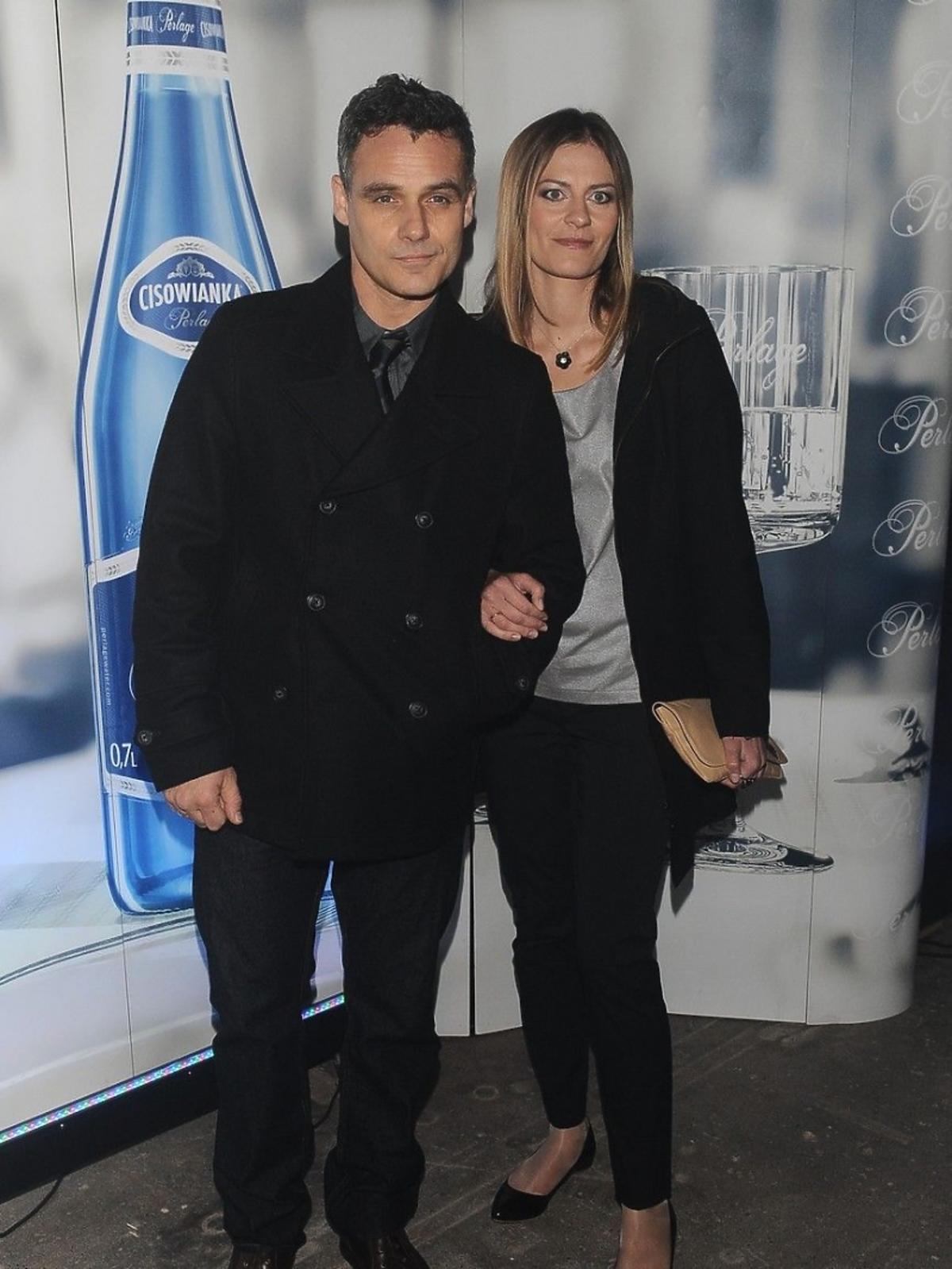 Jan Wieczorkowski w czarnym płaszczu z żoną Urszula Karczmarczyk na pokazie Tomasza Ossolińskiego