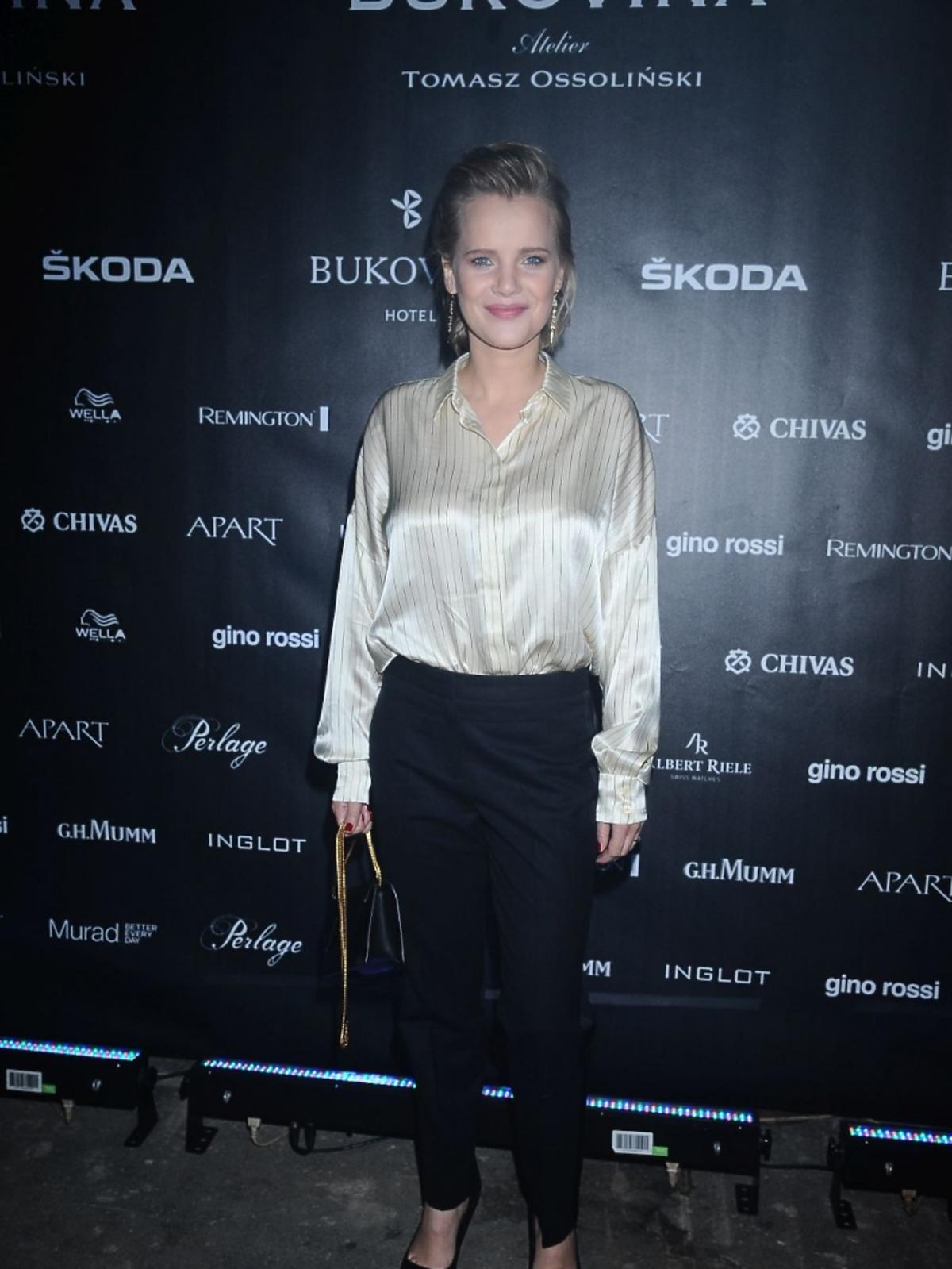 Joanna Kulig w satynowej, złotej koszuli na pokazie Tomasza Ossolińskiego