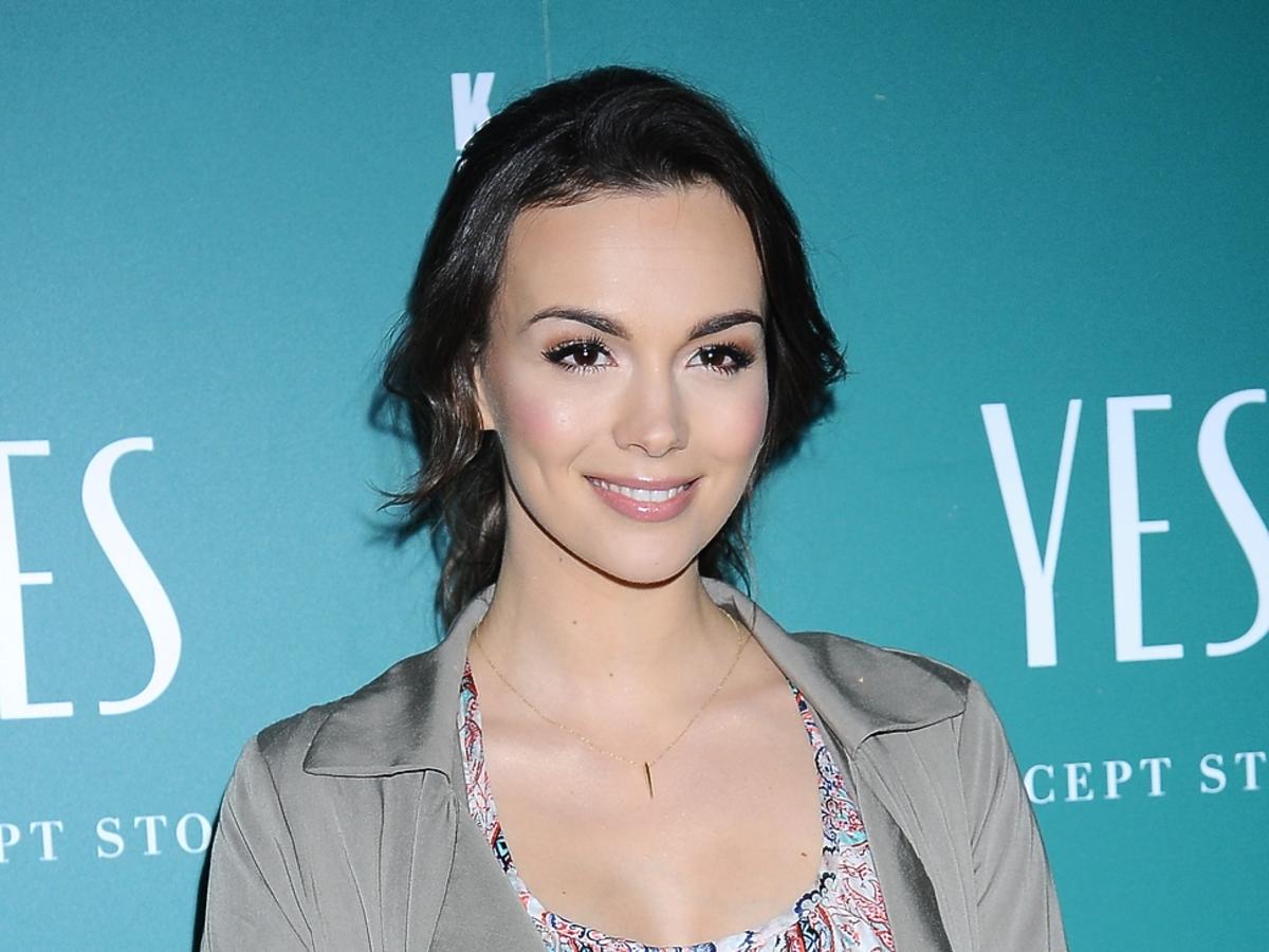 Paulina Krupińska w wiosennej sukience i szarym płaszczu