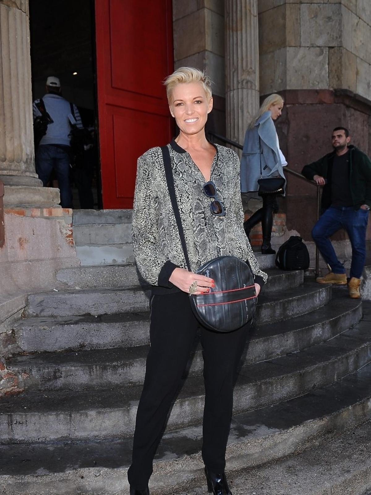 Ilona Felicjańska w czarnych spodniach i okularach na schodach