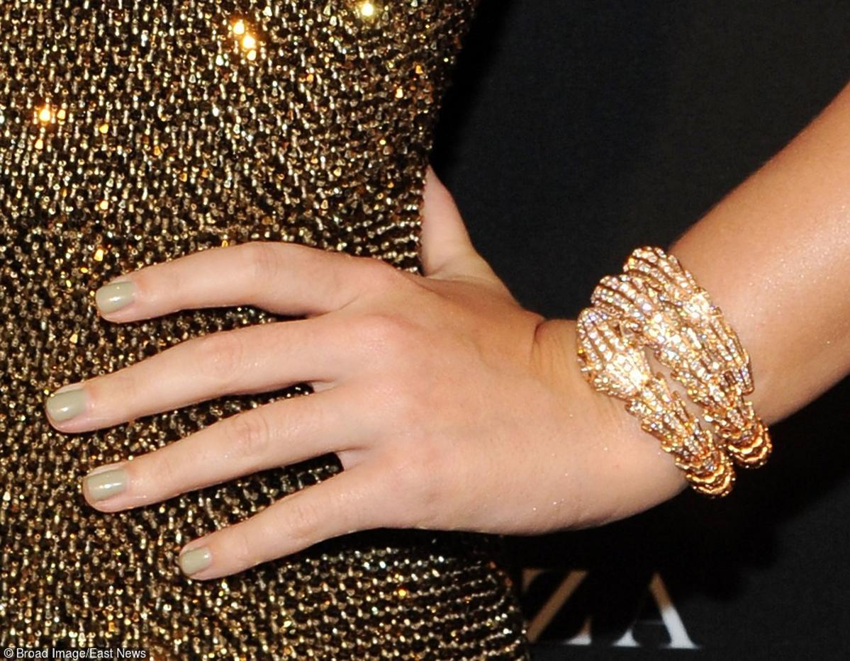 Katy Perry w złotej błyszczącej sukience, ze złotymi bransoletkami