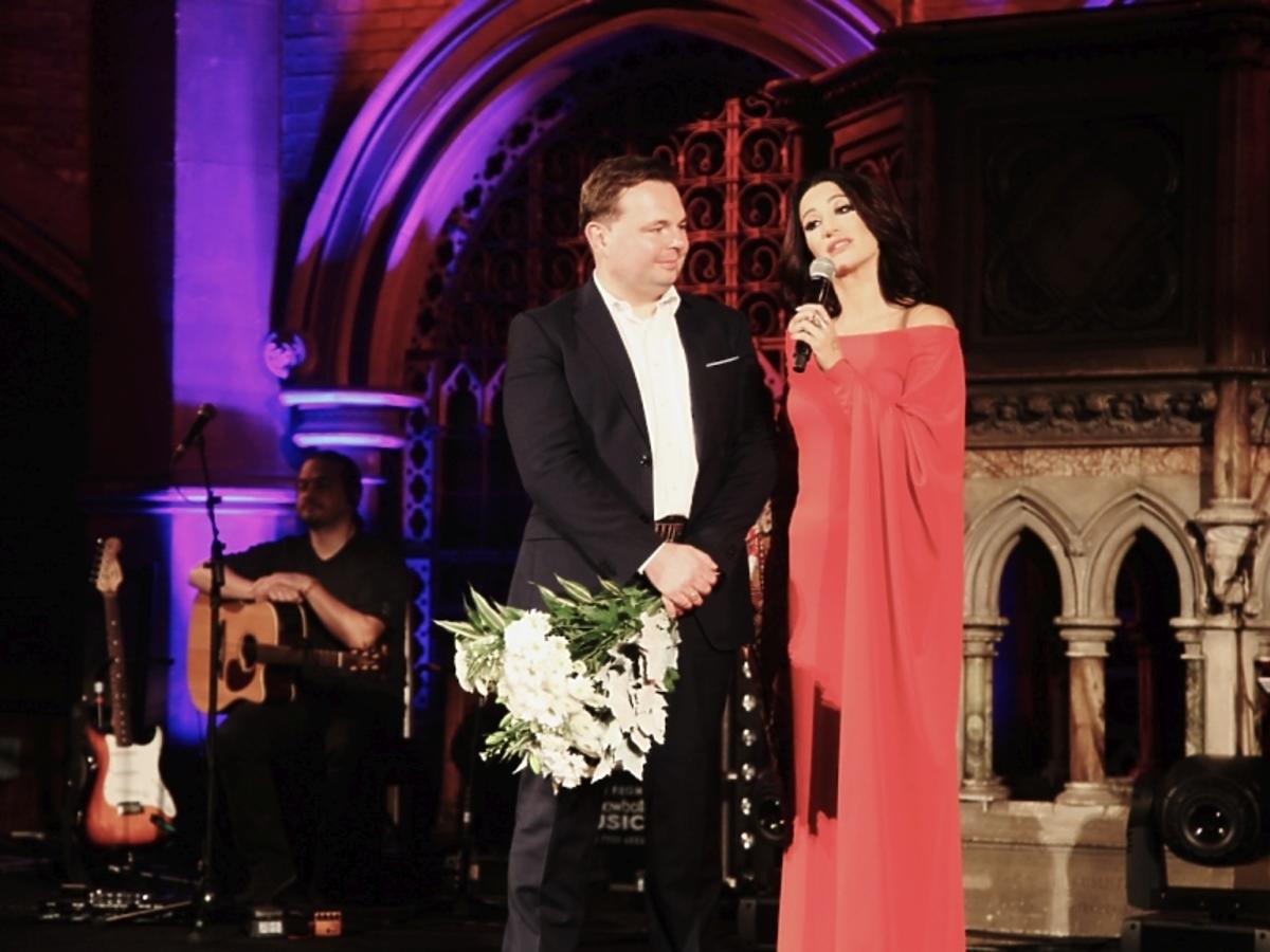 Justyna Steczkowska w katedrze gotyczkiej Union Chapel w czerownej sukni odbiera kwiaty od Polonii
