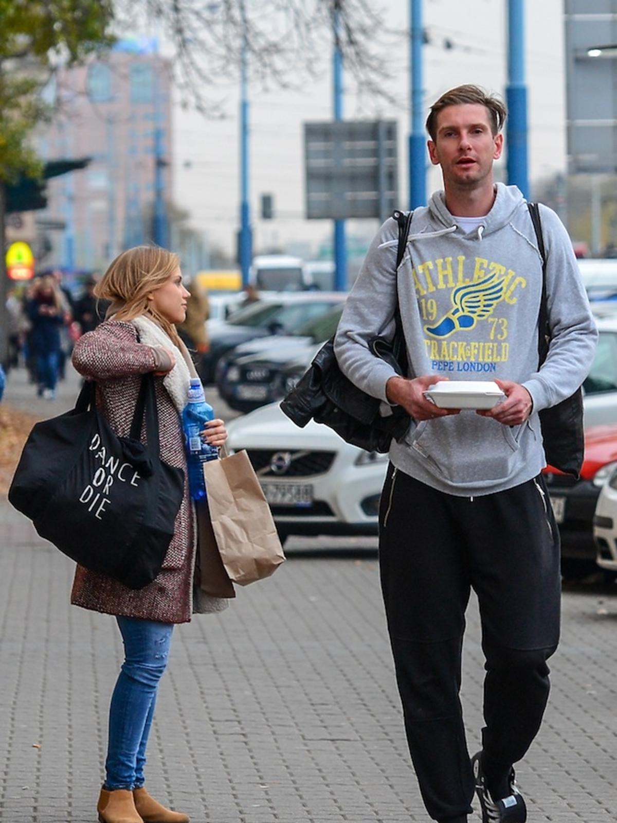 Agnieszka Kaczorowska w dresach i Łukasz Kadziewicz w dresach na ulicy idą na trening