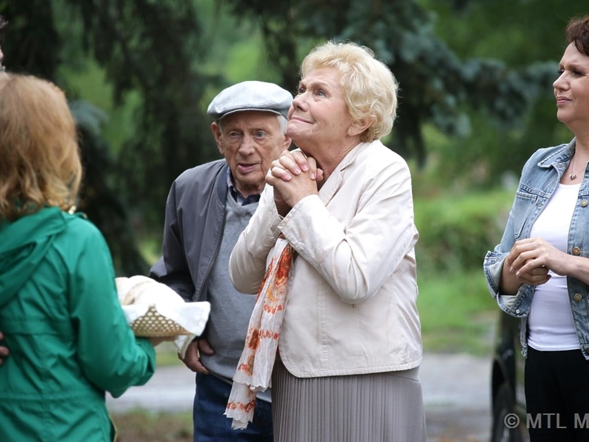 Barbata w jasnym żakeicie i Lucjan Mostowiak w czapce cieszą się, że wracają do odnowionego domu w M jak Miłość