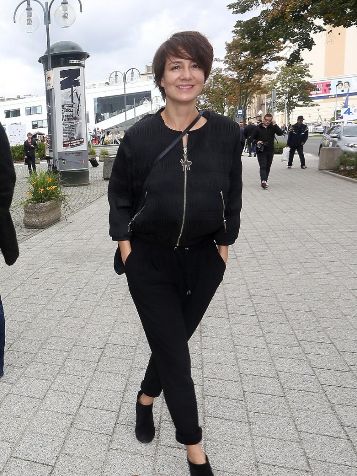Maja Ostaszewska ubrana na czarno idzie chodnikiem