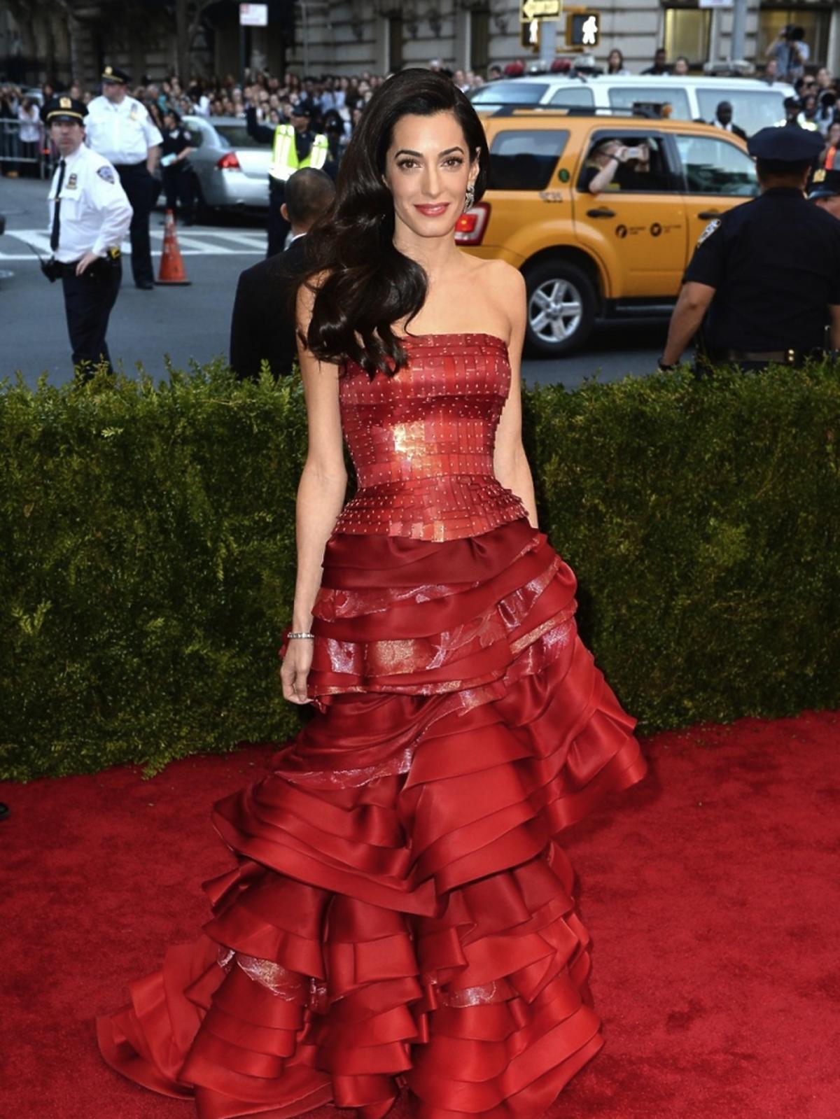 Amal Clooney w czerwonej sukni z falbanami na czerwonym dywanie
