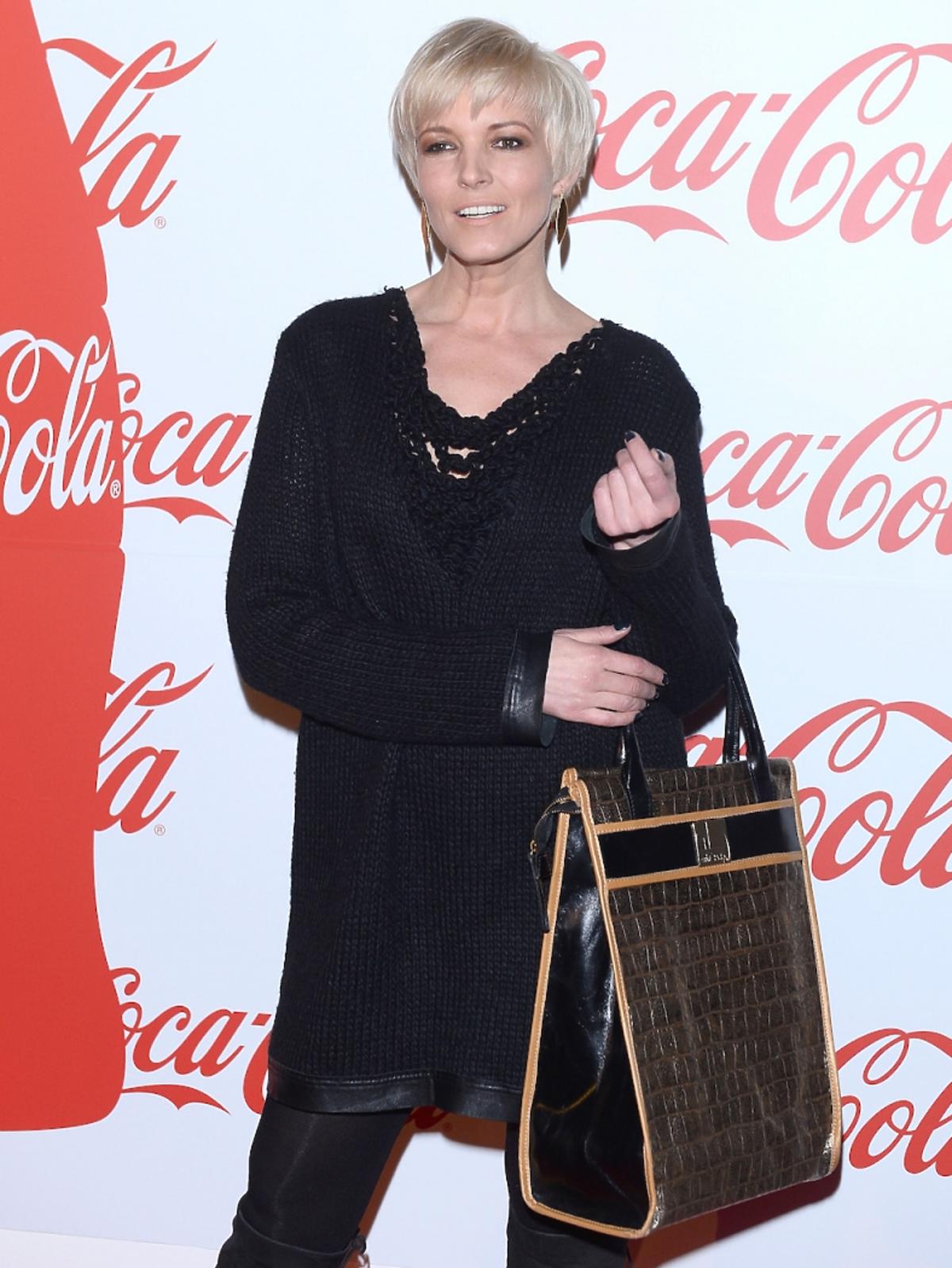Ilona Felicjańska w czarnej bluzce i spodniach i dużą brązową torbą