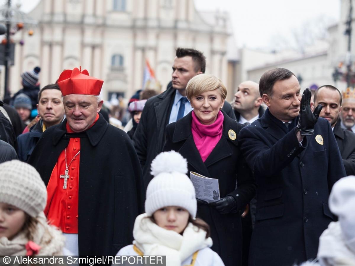 Andrzej Duda w czarnym płaszczu i Agata Duda w amarantowym szaliku na pochodzie Trzech Króli 2016