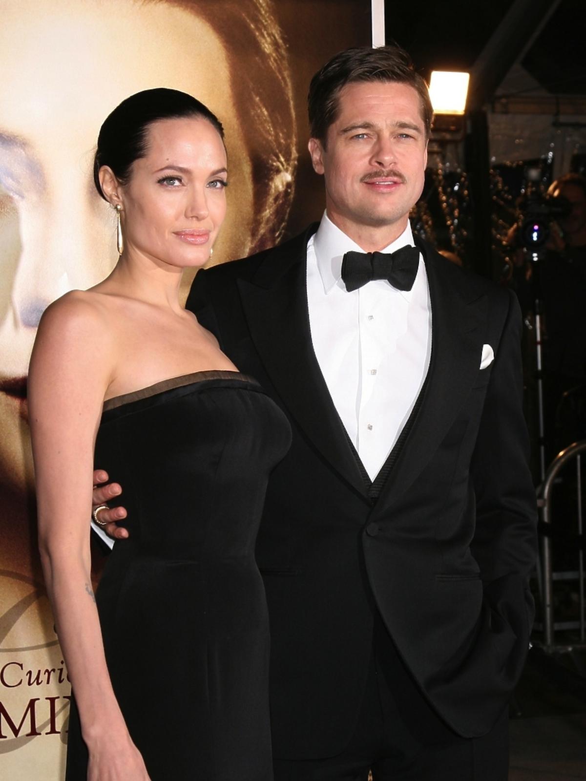 Angelina Jolie w eleganckiej sukni i Brad Pitt w garniturze na czerwonym dywanie