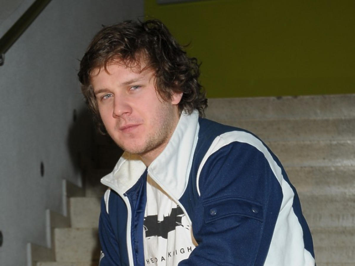 Antoni Królikowski w młodości siedzi na schodach 