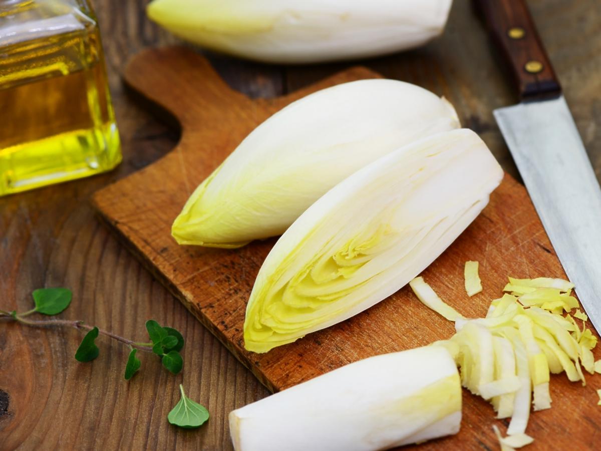 Cykoria na desce do krojenia z oliwą i nożem