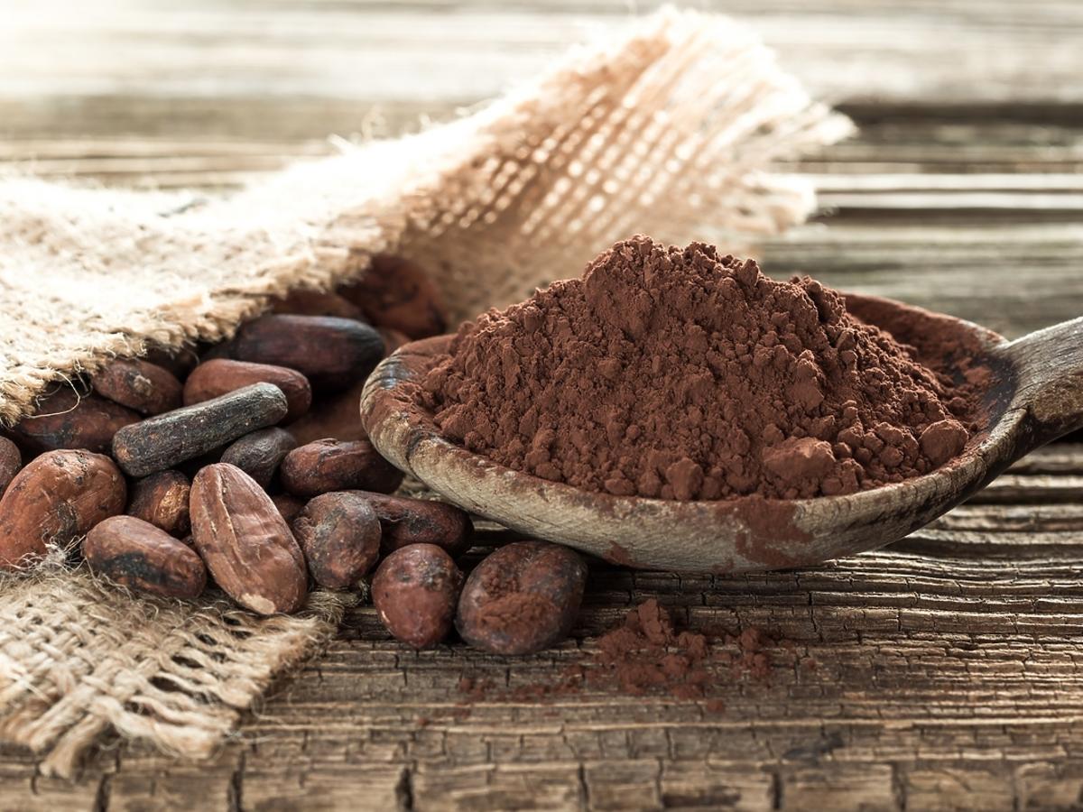 drewniana łyżka z kakao leżąca na brązowym blacie 