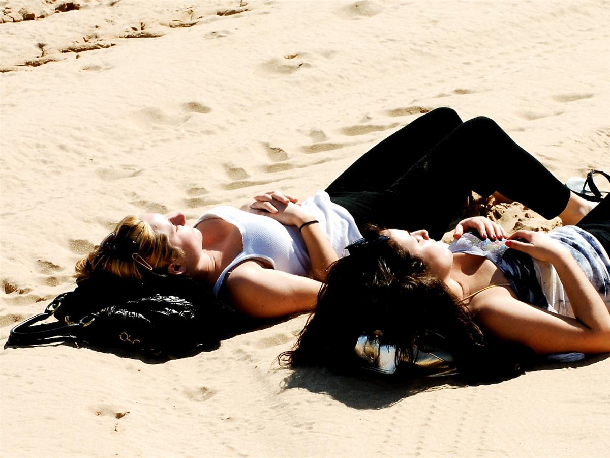 dwie kobiety opalają się na plaży