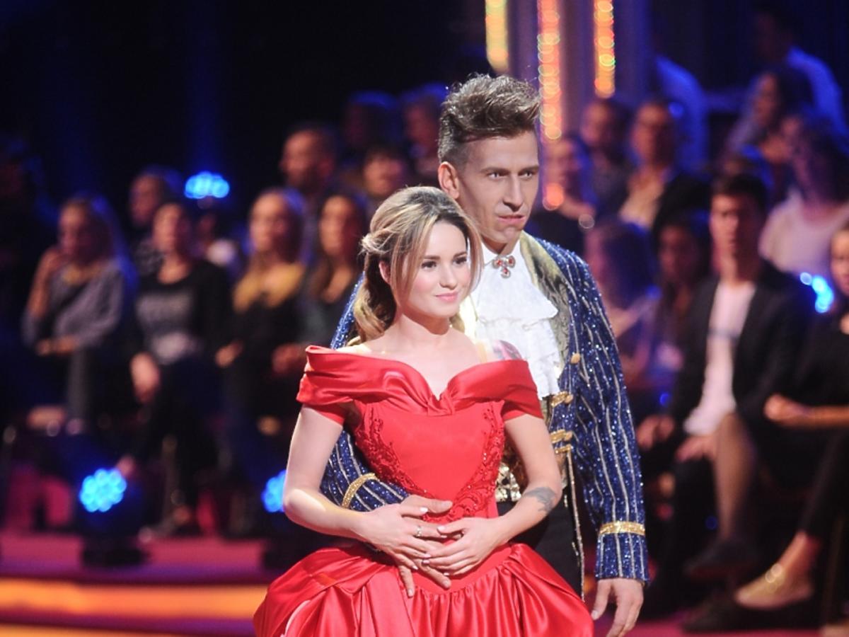 Ewelina Lisowska w czerwonej sukience z krynoliną i Tomasz Barański we fraku i z zębami wampira