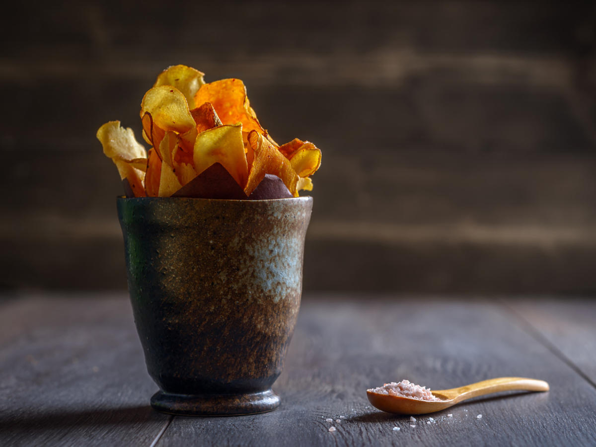 Garść chipsów zrobionych z ogórka leży w misce na stole.
