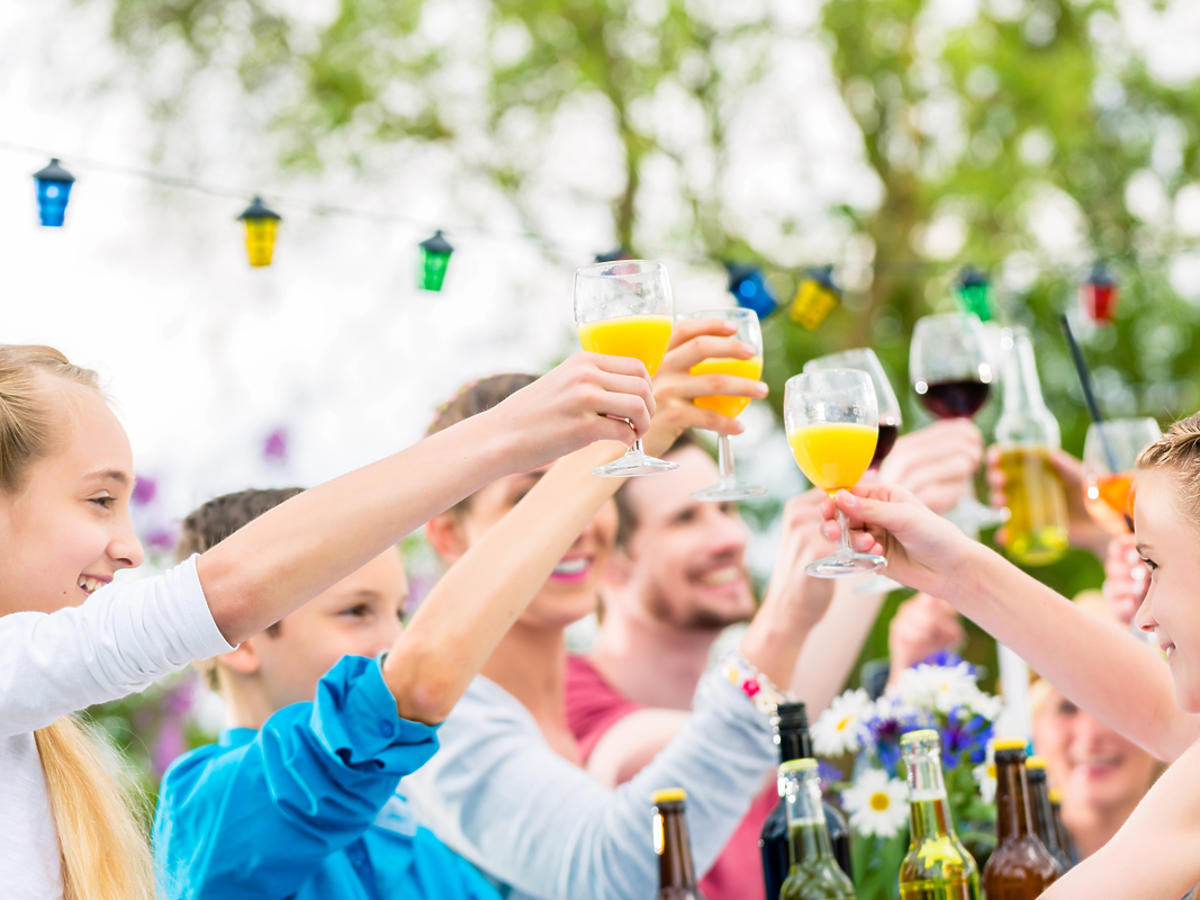 goście wznoszą toast na ogrodowym przyjęciu