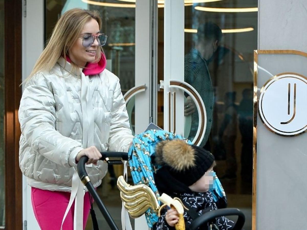 Izabela Janachowska w różowym dresie i jasnej kurtce na spacerze z synem
