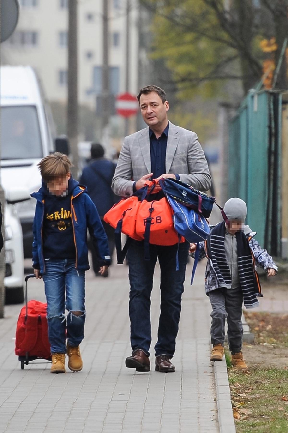 Jacek Rozenek jasnej marynarce z synami Stanisławem i Tadeuszem na ulicy