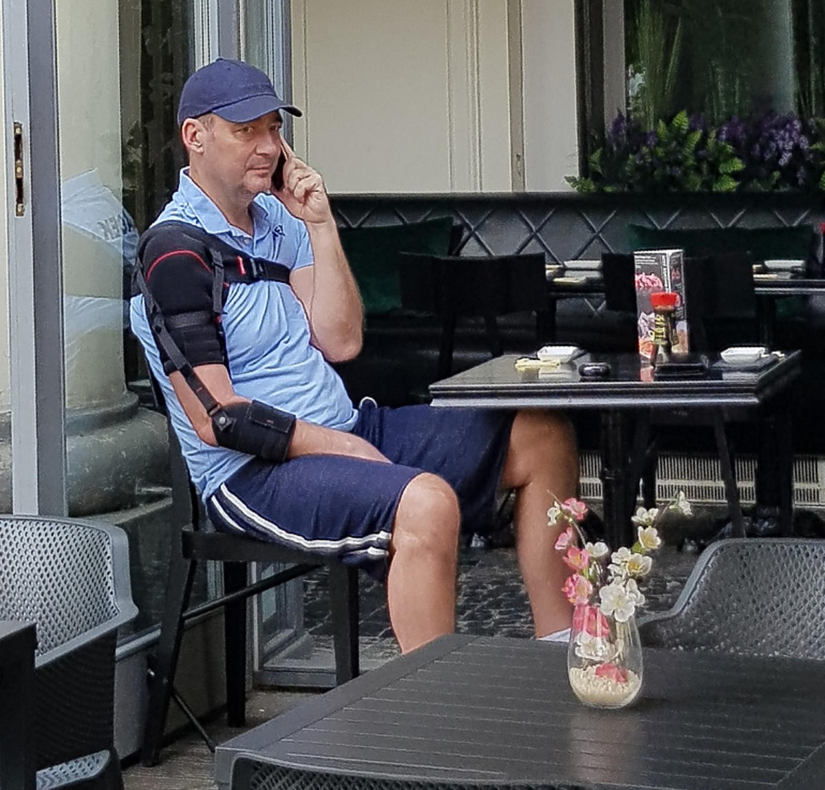 Jacek Rozenek w kawiarni rozmawia przez telefon