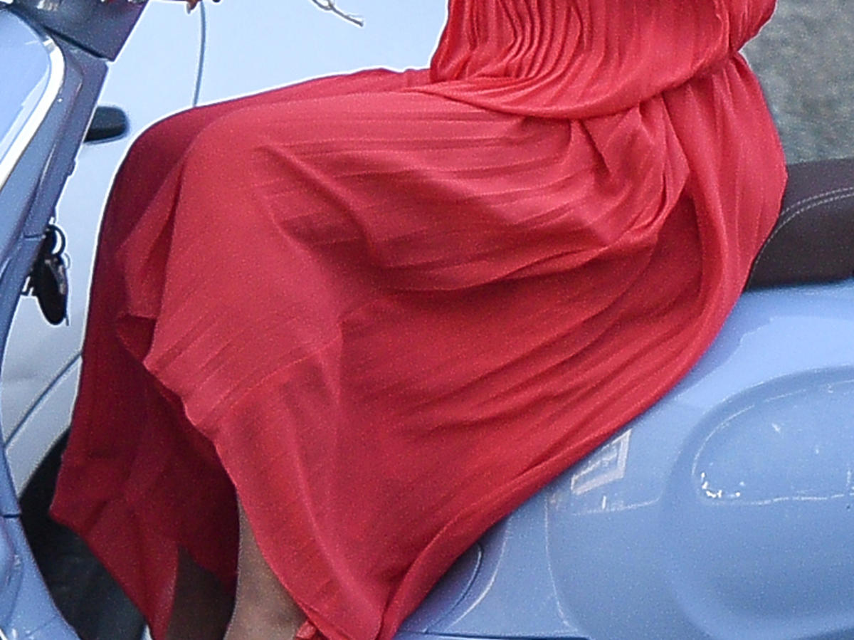Joanna Racewicz w długiej sukni i szpilkach na skuterze