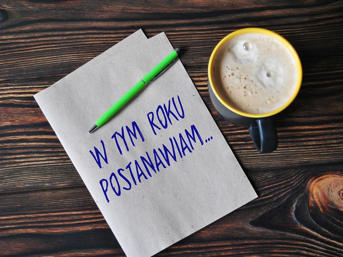 kartka z postanowieniami-noworocznymi i kubek z kawą
