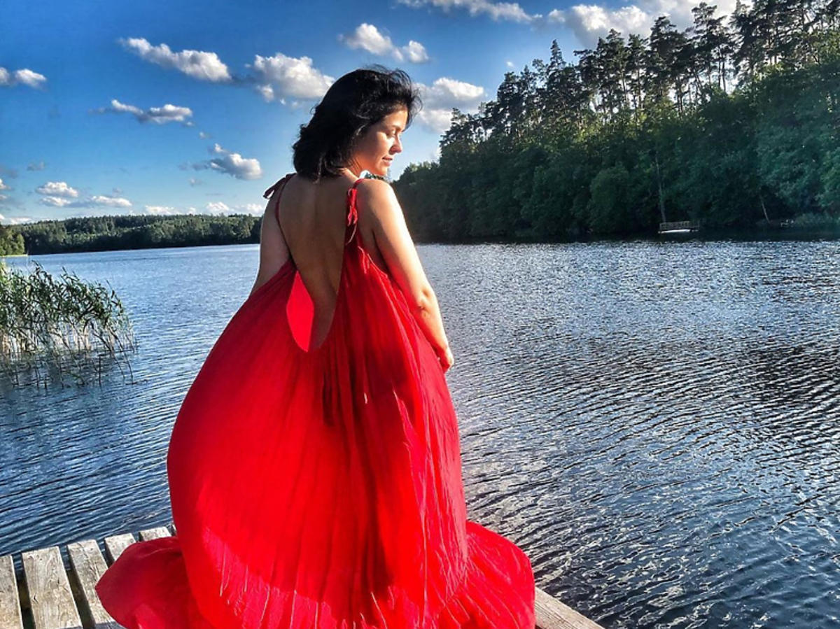 Katarzyna Cichopek w czerwonej sukience na jeziorem