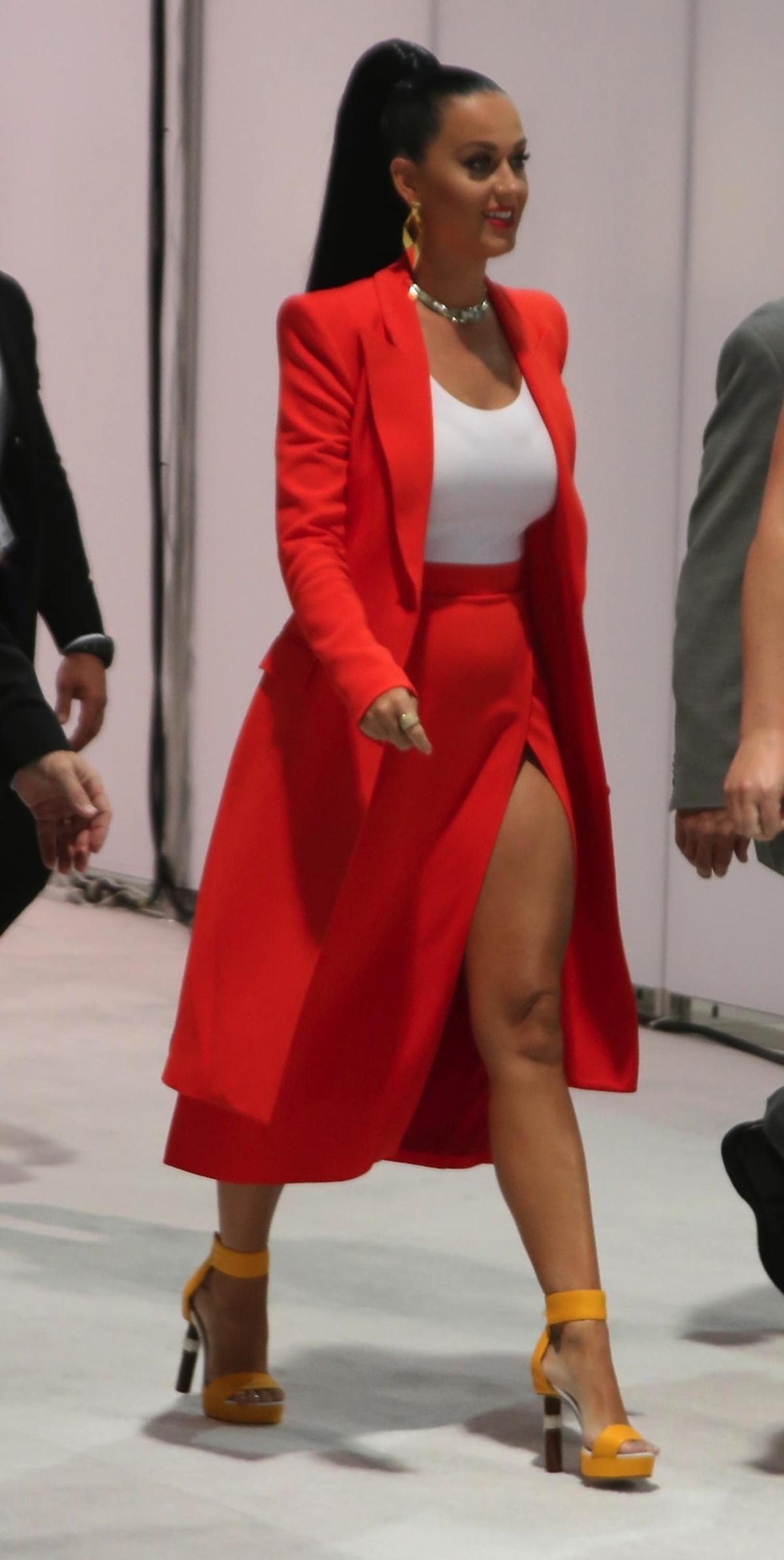 Katy Perry w czerwonej spódnicy z rozcięciem i długim płaszczu