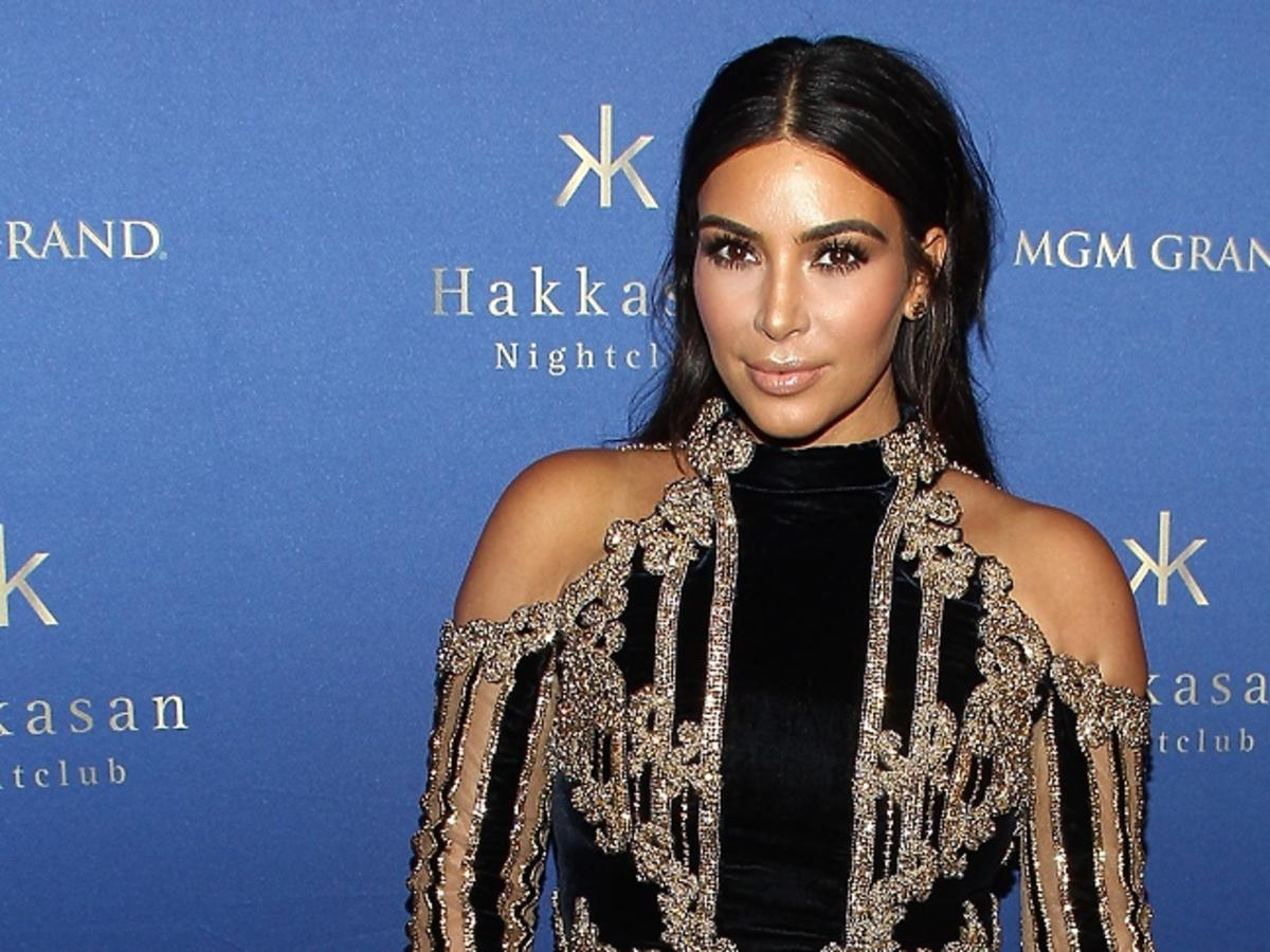 Kim Kardashian w sukience z odkrytymi ramionami w czarno-złote pasy
