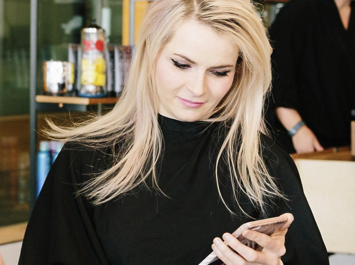 Klientka z blond włosami w salonie fryzjerskim