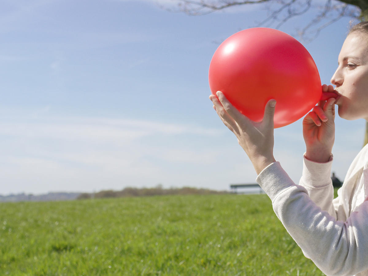 Kobieta nadmuchuje balon