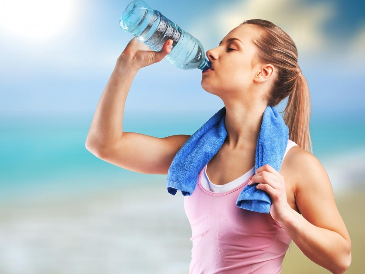 kobieta pijąca wodę podczas treningu
