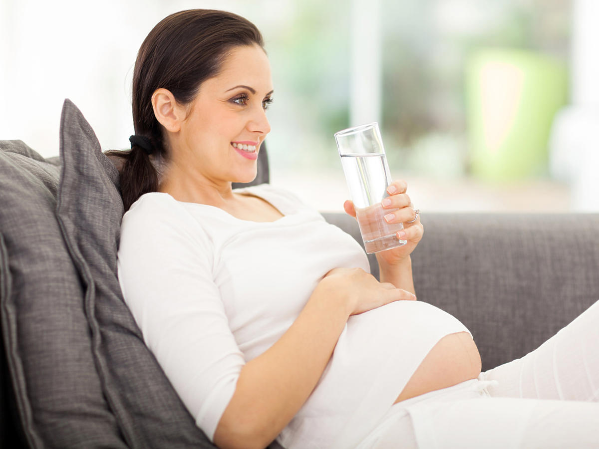 Kobieta w ciąży pije wodę