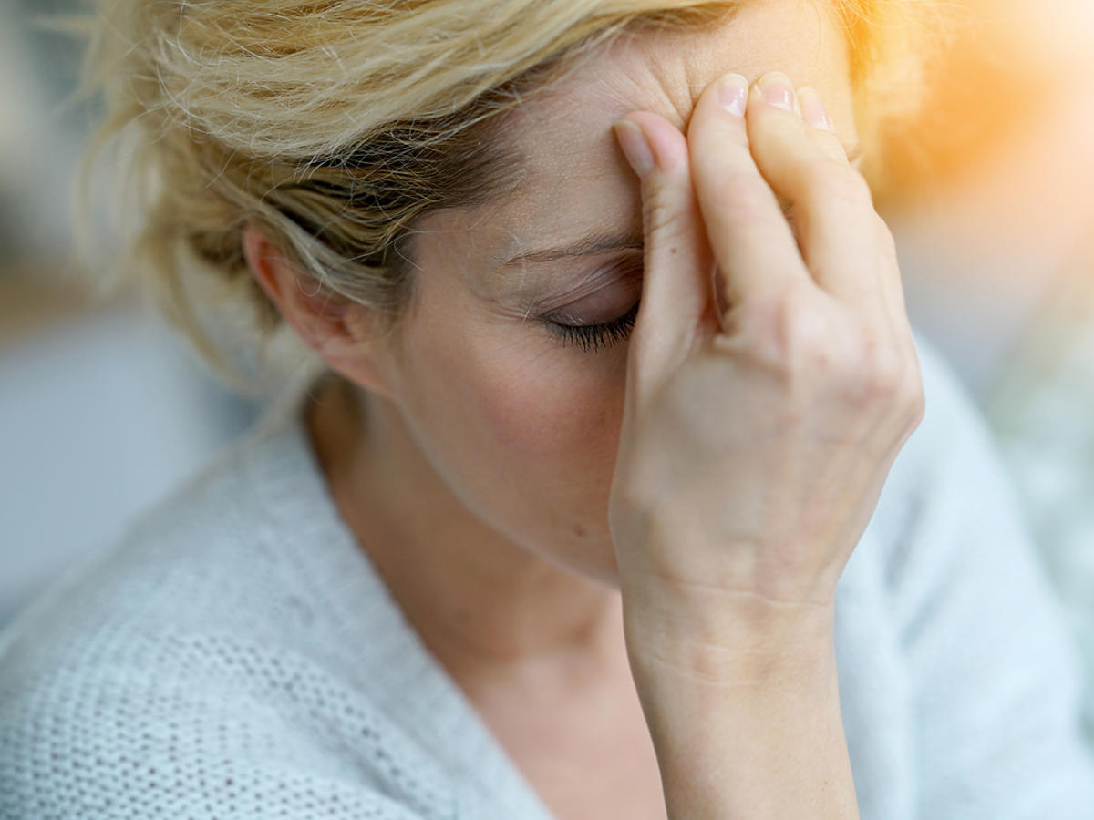kobieta z migreną trzymająca-się za głowę