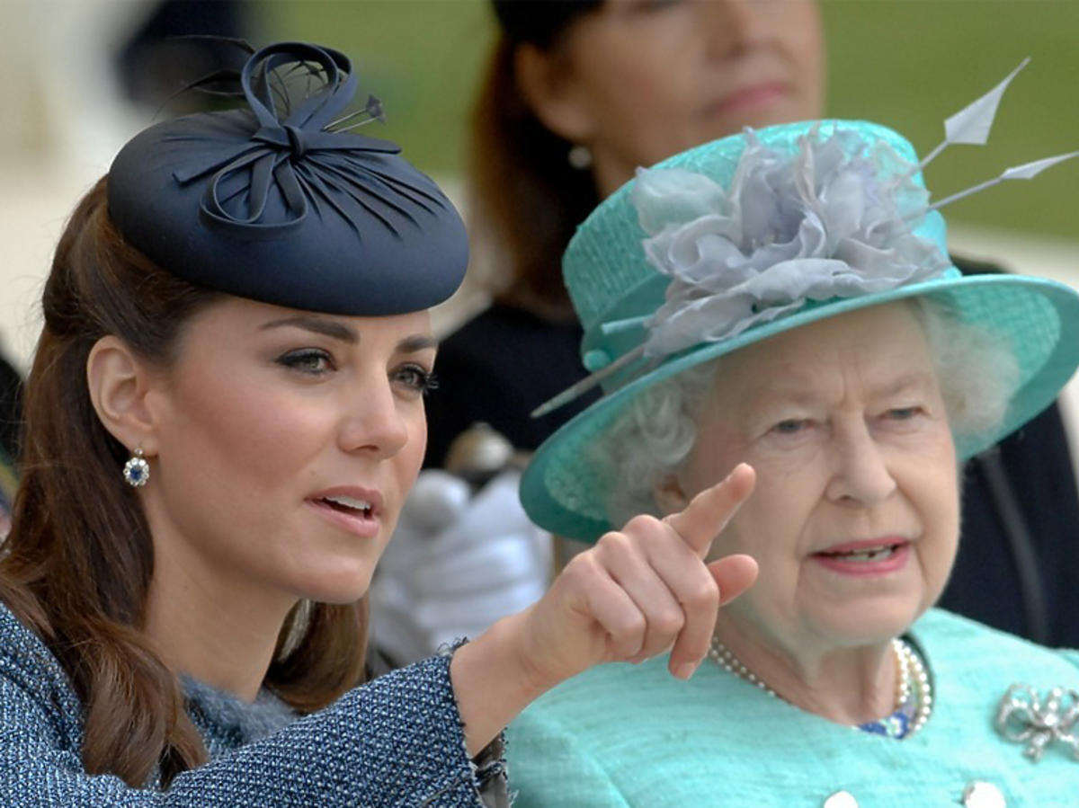 Księżna Kate w toczku i Elżbieta II w miętowej stylizacji oglądają razem przedstawienie