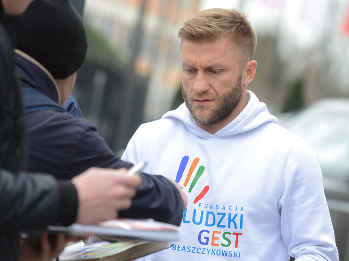 Kuba Błaszczykowski w bluzie swojej fundacji rozdaje autografy