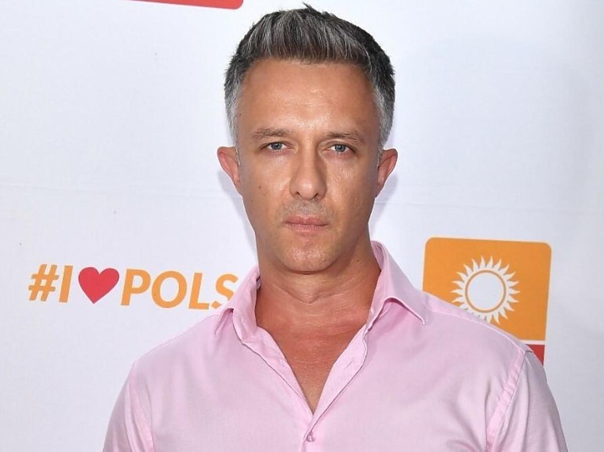 Łukasz Płoszajski w różowej koszuli