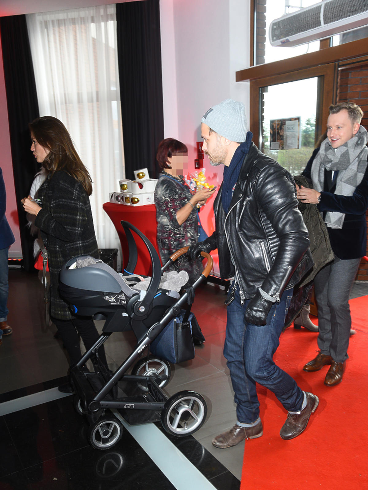 Maciej Zakościelny z dzieckiem na imprezie mikołajkowej