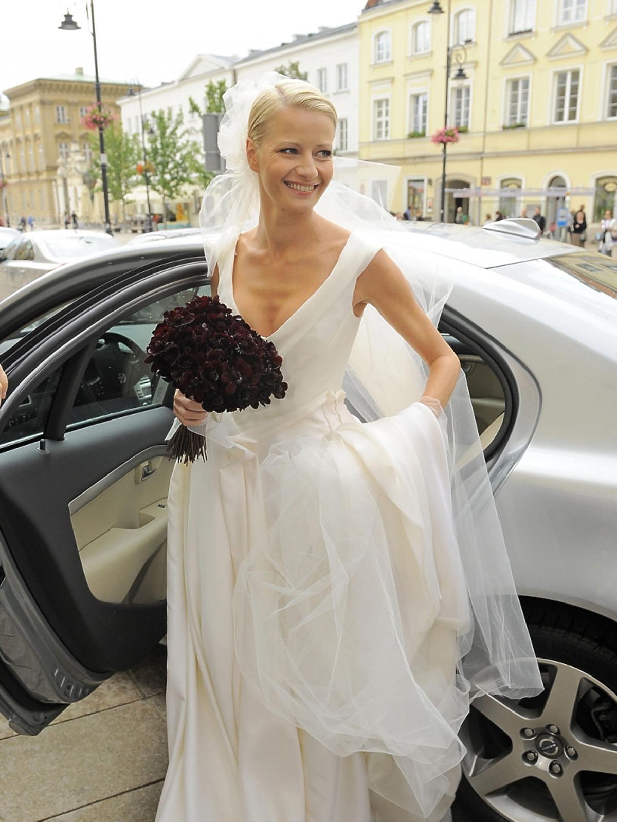 Małgorzata Kożuchowska w sukni ślunej z welonem i bukietem kwiatów