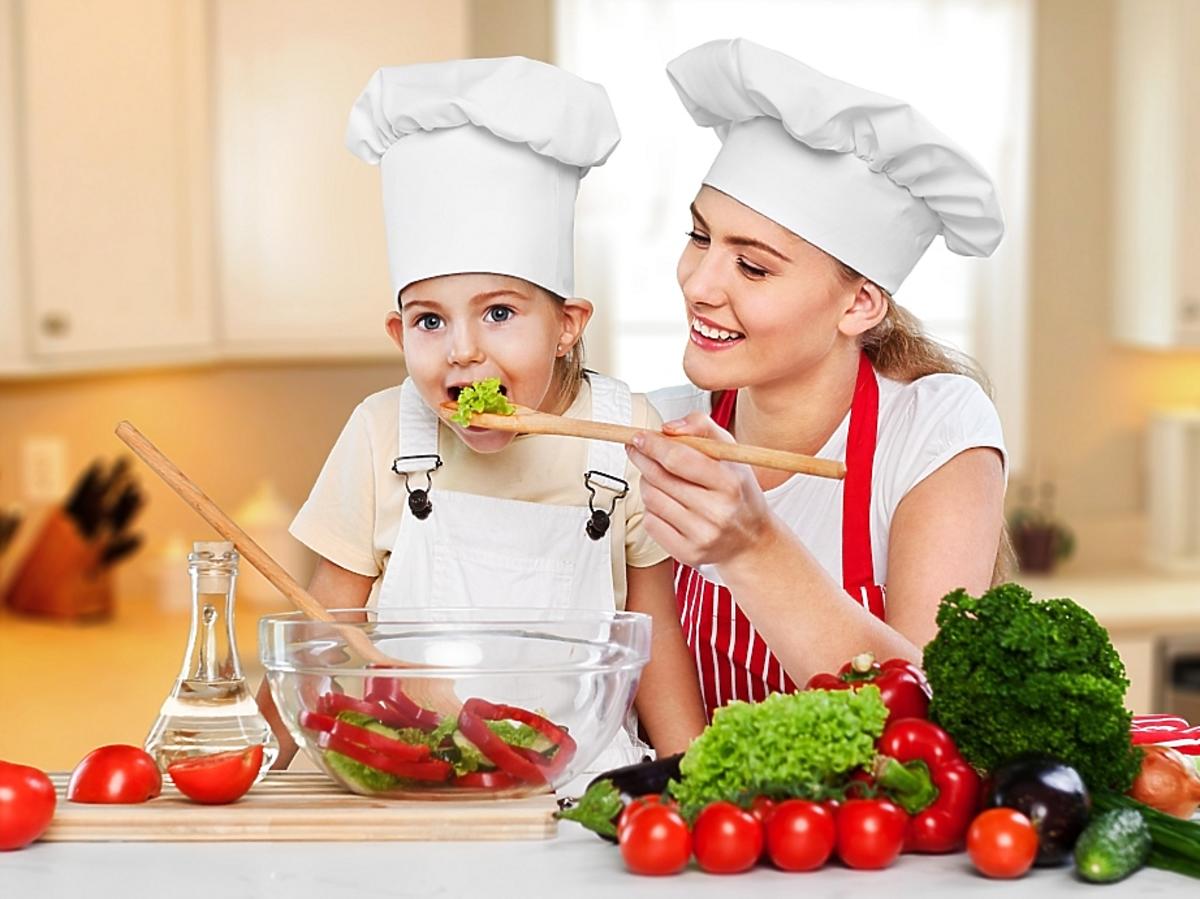 Mama z dzieckiem przyrządza potrawę z wielu warzyw