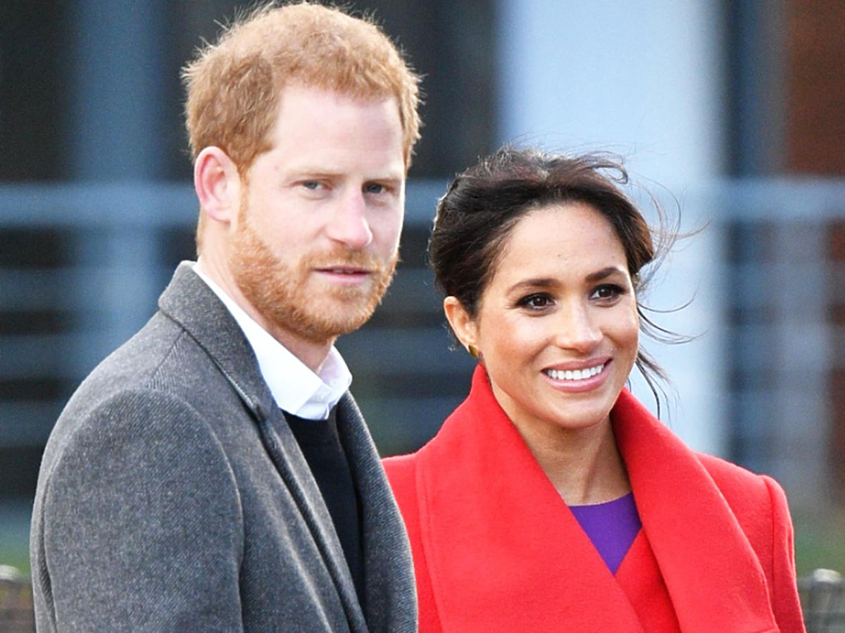 Meghan Markle w czerwonym płaszczu z księciem Harrym