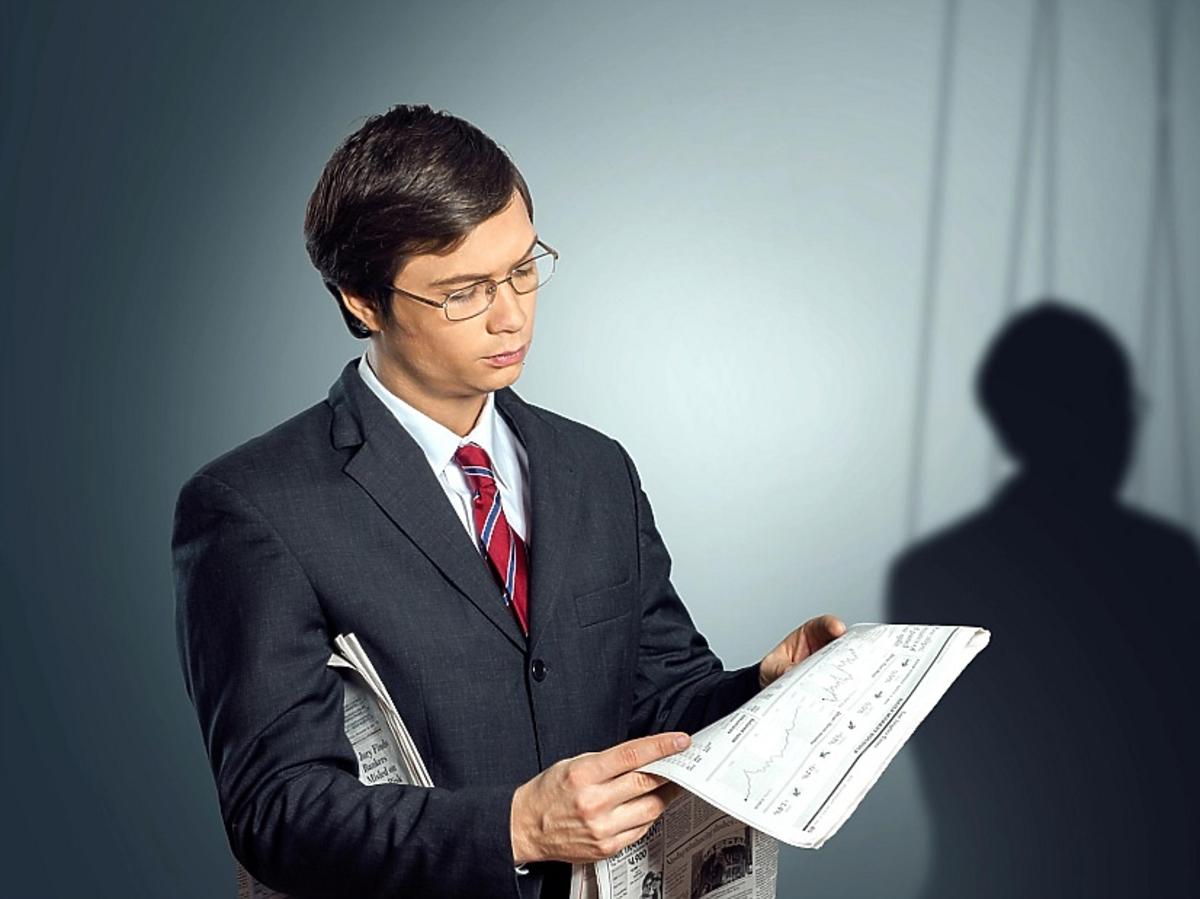 Mężczyzna w okularach czytający konspekt