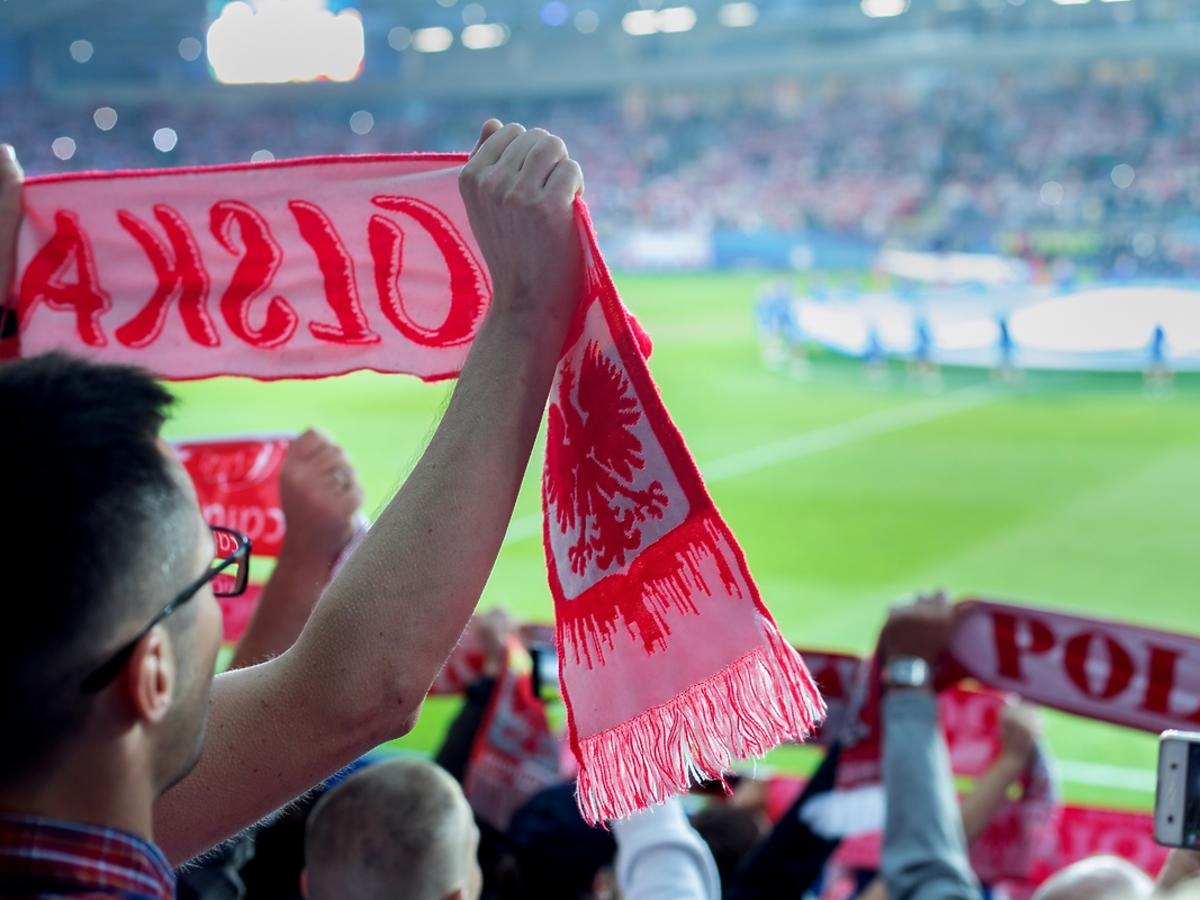 Mężczyźni kibicują polskiej reprezentacji na meczu.