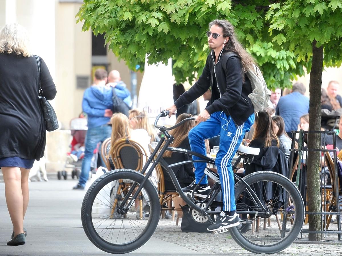 Michał Szpak na rowerze w niebieskich dresach
