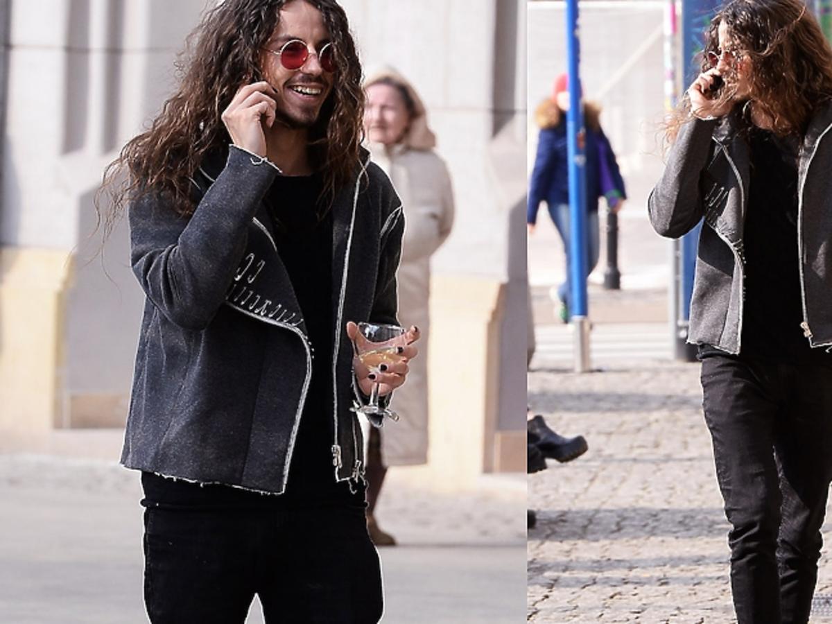 Michał Szpak z kieliszkiem wina na ulicach Warszawy