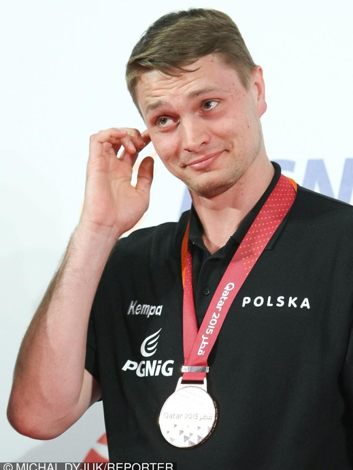 Michał Szyba z brązowym medalem drapie się po uchu