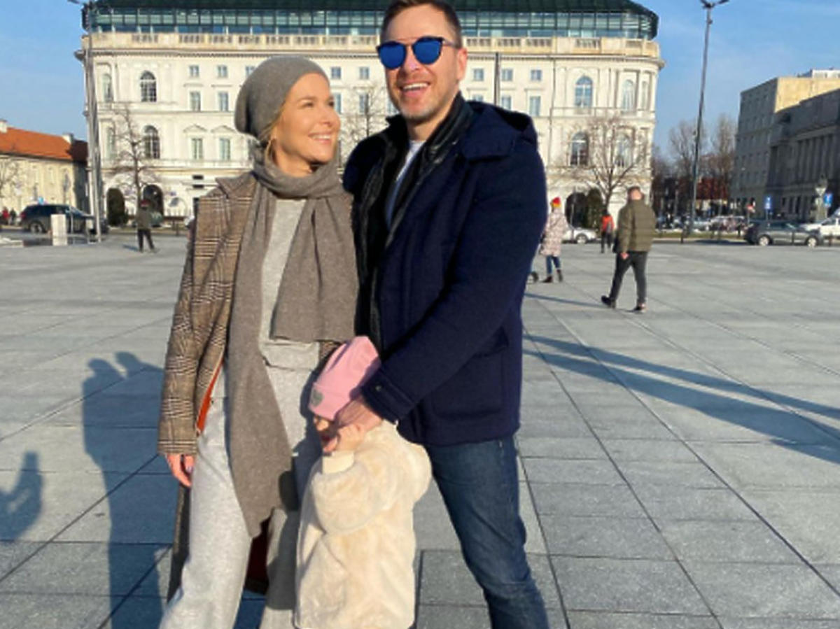 Paulina Sykut-Jeżyna z mężem i córką pozują do zdjęcia na pl. Piłsudkskiego w Warszawie