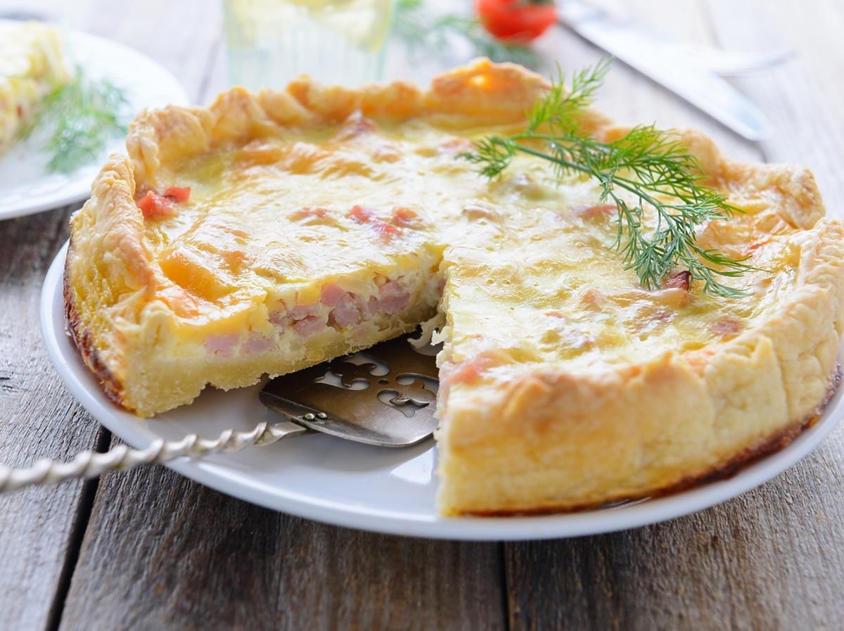 quiche z warzywami i łososiem na białym talerzu