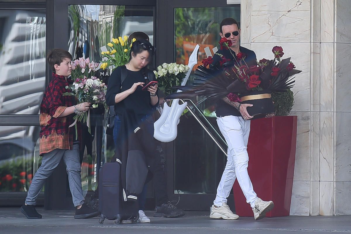 Radosław Majdan niesie kwiaty do samochodu