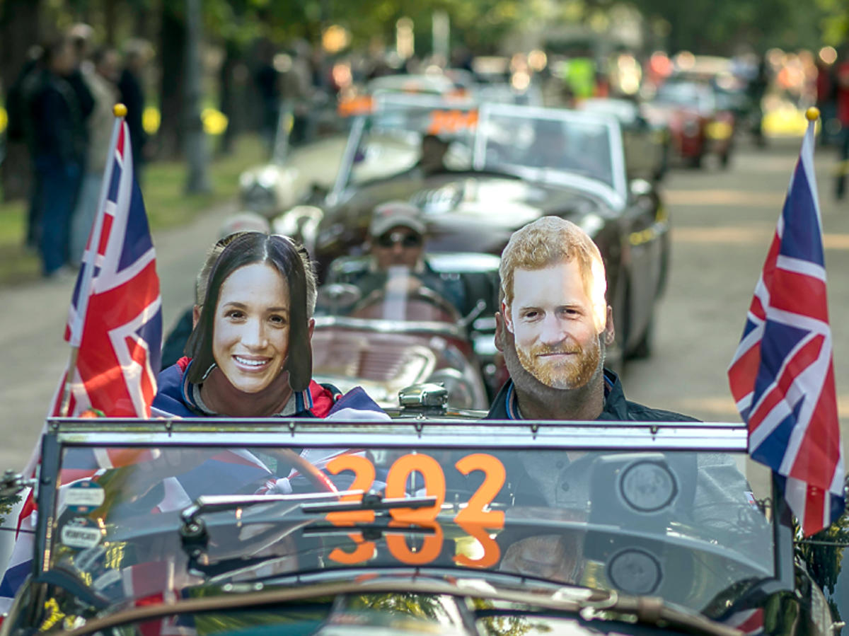 Rajd "Mille Miglia", zdjęcie z trasy - kierowca i pilot w maskach Meghan i Harry'ego